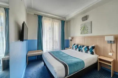 Un ou plusieurs lits dans un hébergement de l'établissement Hotel Phenix Paris