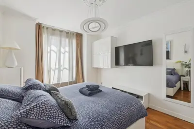 Télévision ou salle de divertissement dans l'établissement Élégance parisienne près des Champs-Élysées