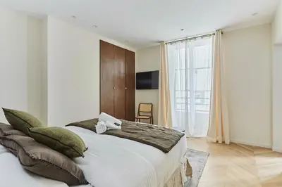 Un ou plusieurs lits dans un hébergement de l'établissement Apartment Champs Elysée bu Studio prestige