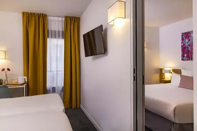Un ou plusieurs lits dans un hébergement de l'établissement Hotel Paris Louis Blanc