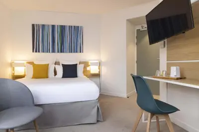 Un ou plusieurs lits dans un hébergement de l'établissement Hotel Paris Louis Blanc