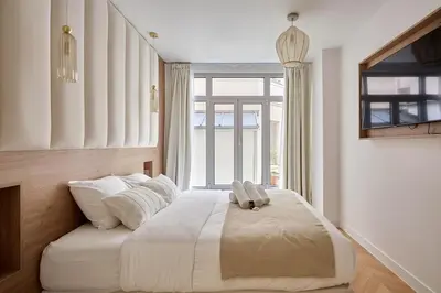 Un ou plusieurs lits dans un hébergement de l'établissement Apartment Centre de Paris by Studio prestige