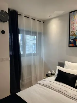 Un ou plusieurs lits dans un hébergement de l'établissement Cosy Studio paris 16 Victor Hugo