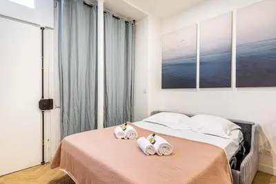 Un ou plusieurs lits dans un hébergement de l'établissement Appartement moderne pour 4 proche Arc de Triomphe