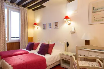 Un ou plusieurs lits dans un hébergement de l'établissement Hôtel du Cygne Paris