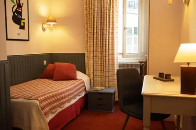 Un ou plusieurs lits dans un hébergement de l'établissement Hôtel du Cygne Paris