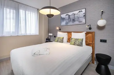 Un ou plusieurs lits dans un hébergement de l'établissement Appart'hôtel East Paris Suite