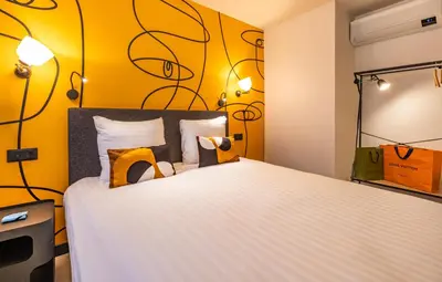 Un ou plusieurs lits dans un hébergement de l'établissement Appart'hôtel East Paris Suite