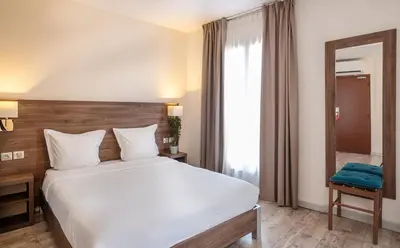 Un ou plusieurs lits dans un hébergement de l'établissement Hotel la Perle Montparnasse