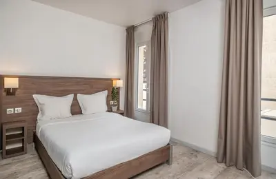 Un ou plusieurs lits dans un hébergement de l'établissement Hotel la Perle Montparnasse