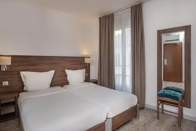 Un ou plusieurs lits dans un hébergement de l'établissement Hotel la Perle Montparnasse