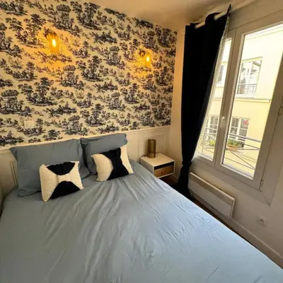 Un ou plusieurs lits dans un hébergement de l'établissement Cosy Appartement Paris Center