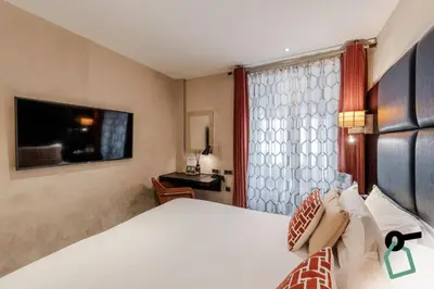Télévision ou salle de divertissement dans l'établissement Hotiday Room Collection - Paris Arc de Triomphe