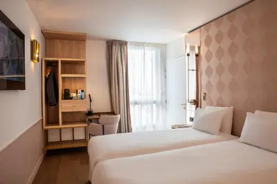 Un ou plusieurs lits dans un hébergement de l'établissement Hôtel Kyriad Prestige Paris Asnieres