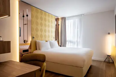 Un ou plusieurs lits dans un hébergement de l'établissement Hôtel Kyriad Prestige Paris Asnieres
