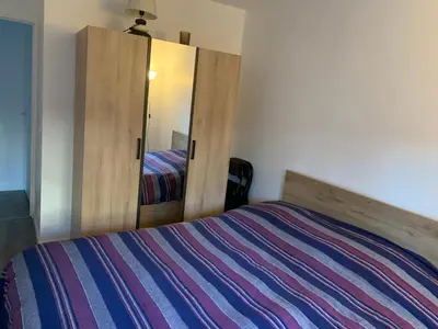 Un ou plusieurs lits dans un hébergement de l'établissement Charmant appartement avec la terrasse