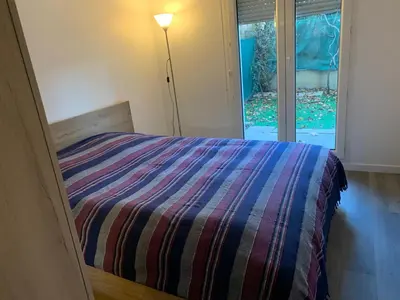 Un ou plusieurs lits dans un hébergement de l'établissement Charmant appartement avec la terrasse