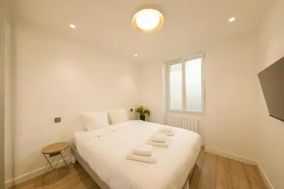 Un ou plusieurs lits dans un hébergement de l'établissement Cosy apartment 3P - Place de l'Etoile