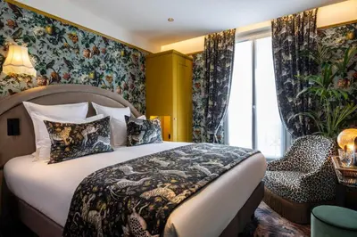 Un ou plusieurs lits dans un hébergement de l'établissement Hôtel Ginette à la Folie & Spa