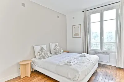 Un ou plusieurs lits dans un hébergement de l'établissement Appartement Cosy Vue sur Paris Bois de Boulogne