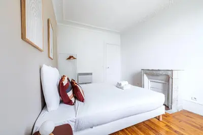 Un ou plusieurs lits dans un hébergement de l'établissement Grand Appartement chaleureux à Puteaux
