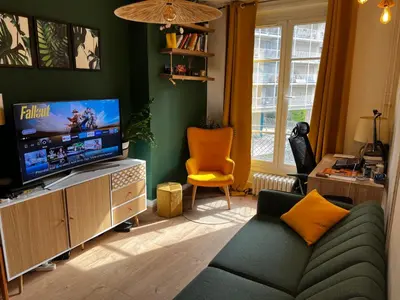Télévision ou salle de divertissement dans l'établissement Un charmant appartement à côté de la cité florale