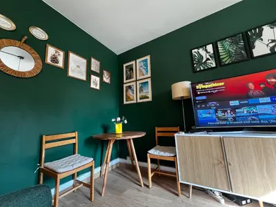 Télévision ou salle de divertissement dans l'établissement Un charmant appartement à côté de la cité florale