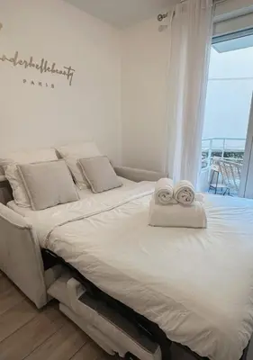 Un ou plusieurs lits dans un hébergement de l'établissement Charmant Studio avec Balcon