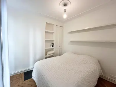 Un ou plusieurs lits dans un hébergement de l'établissement Appartement à côté du Musée Grévin
