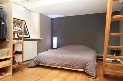 Un ou plusieurs lits dans un hébergement de l'établissement Unique Loft in Paris near Parc de la Villette
