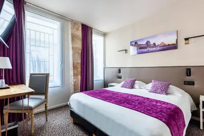 Un ou plusieurs lits dans un hébergement de l'établissement hotel Louvre Sainte Anne
