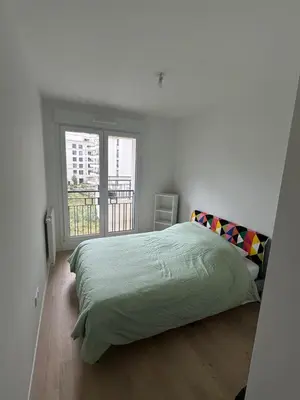 Un ou plusieurs lits dans un hébergement de l'établissement Appartement calme et lumineux avec 2 chambres et un parking
