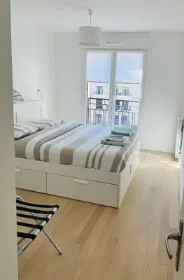 Un ou plusieurs lits dans un hébergement de l'établissement Appartement calme et lumineux avec 2 chambres et un parking