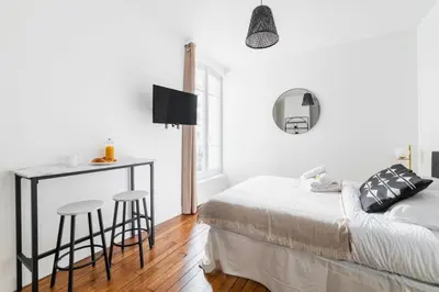 Un ou plusieurs lits dans un hébergement de l'établissement Appartement service Studio au Coeur du 19e - 2P