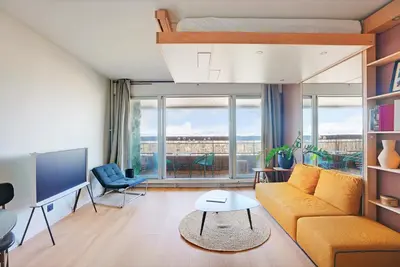 Coin salon dans l'établissement Studio refait à neuf avec balcon et vue sur la Seine - bail mobilité