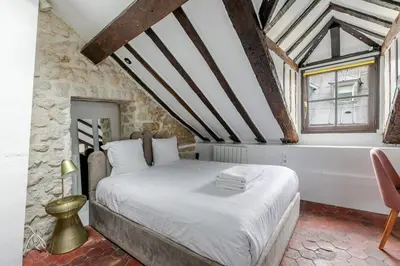 Un ou plusieurs lits dans un hébergement de l'établissement Studio sous les poutres à Paris