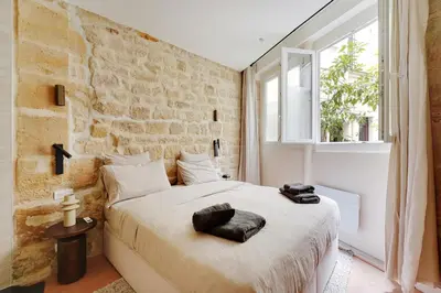 Un ou plusieurs lits dans un hébergement de l'établissement Appartement haut de gamme avec 2 salles de bains et climatisation au cœur du Marais