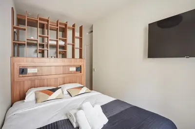 Un ou plusieurs lits dans un hébergement de l'établissement Appart'Hôtel Lou Suites