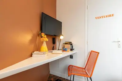 Télévision ou salle de divertissement dans l'établissement Hotel Olympic Paris Boulogne by Patrick Hayat