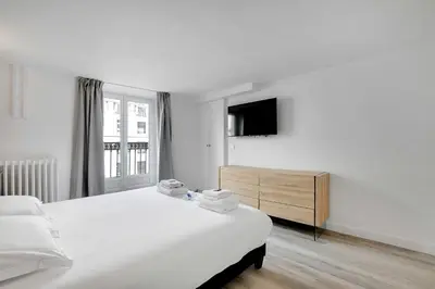 Un ou plusieurs lits dans un hébergement de l'établissement Charmant appartement- 3BR-8P- Opéra
