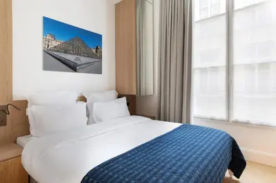 Un ou plusieurs lits dans un hébergement de l'établissement Louvre élégance appartements de charme