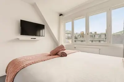 Un ou plusieurs lits dans un hébergement de l'établissement Ecrin Parisien Cosy & Chic Au pied des Champs Élysées 1 min