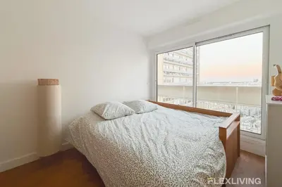 Un ou plusieurs lits dans un hébergement de l'établissement Spacieux T3 dans le 13ème avec petit balcon et vu sur les toits de Paris