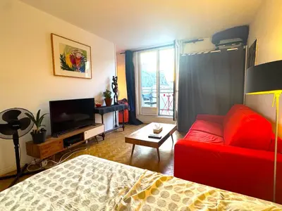 Télévision ou salle de divertissement dans l'établissement Grand studio vue sur la Tour Eiffel