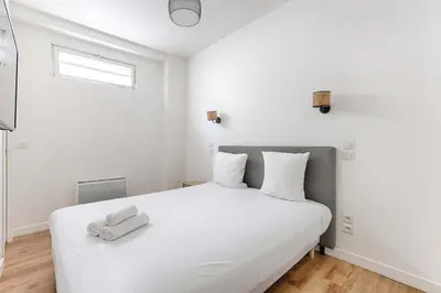 Un ou plusieurs lits dans un hébergement de l'établissement 2BR Montmartre Chapelle Apartment