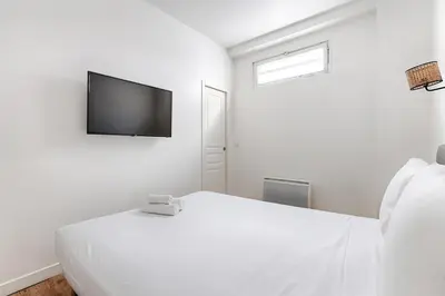Un ou plusieurs lits dans un hébergement de l'établissement 2BR Montmartre Chapelle Apartment