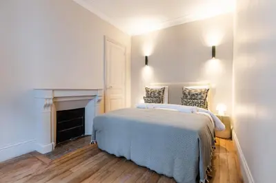 Un ou plusieurs lits dans un hébergement de l'établissement Elegant 3-Bedroom Apartment in the Heart of Historic Paris