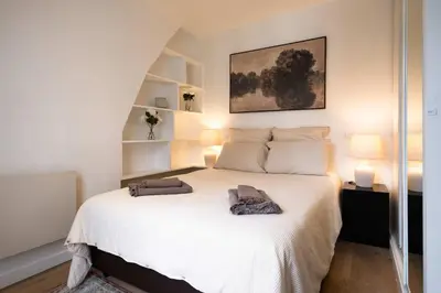 Un ou plusieurs lits dans un hébergement de l'établissement Bright 2BR with Balcony Chic Paris