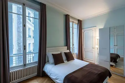 Un ou plusieurs lits dans un hébergement de l'établissement Big 3BR Apartment for 9 - Near Arc de Triomphe