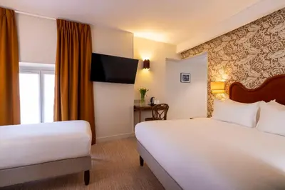 Un ou plusieurs lits dans un hébergement de l'établissement Hotel Michelet Odeon